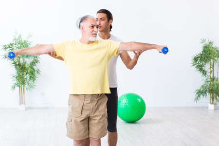 Old man doing exercises indoorsの写真素材