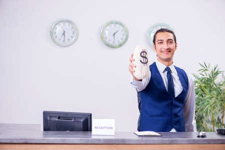 Young man receptionist at the hotel counterの写真素材