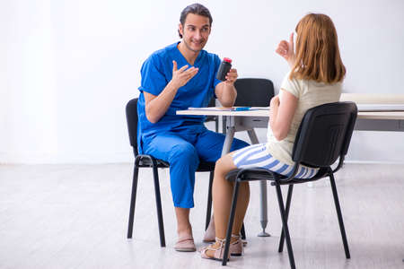 Pregnant woman visiting male doctor gynecologistの写真素材