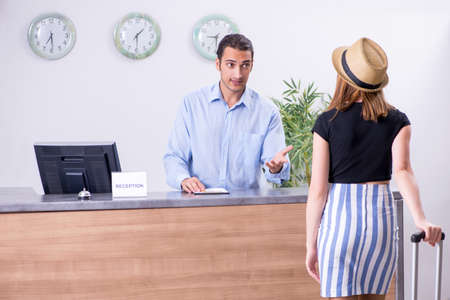 Young woman at hotel receptionの写真素材
