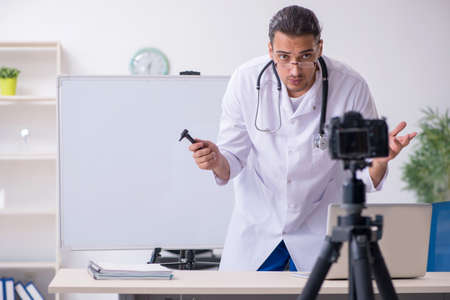 Young male doctor recording video for his blog