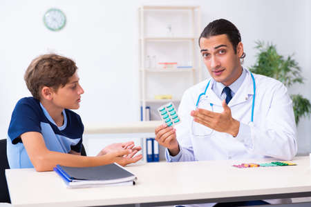 Young male doctor examining boy in the clinicの写真素材