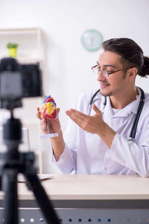 Young male doctor cardiologist recording video for his blogの写真素材