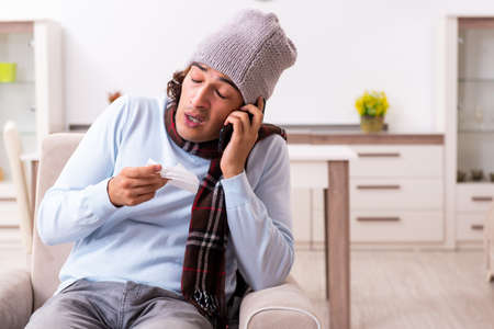 Young man suffering from flu at homeの写真素材