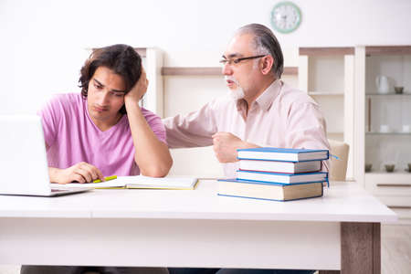 Old father helping his son in exam preparationの写真素材
