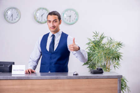 Young man receptionist at the hotel counterの写真素材