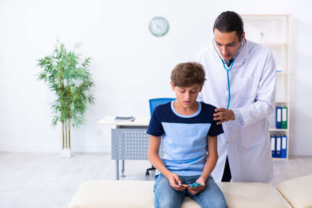 Young male doctor examining boy in the clinicの写真素材