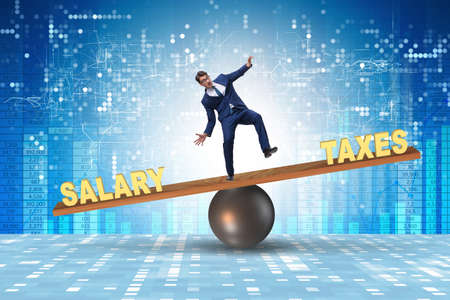 Businessman balancing between taxes and salaryの写真素材