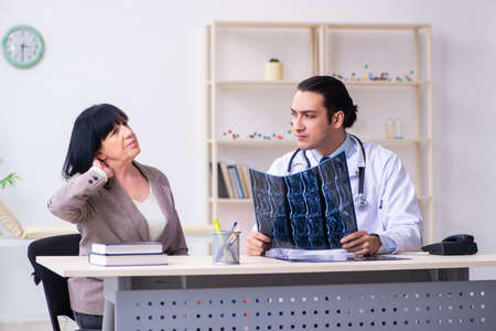 Young doctor examining senior old woman