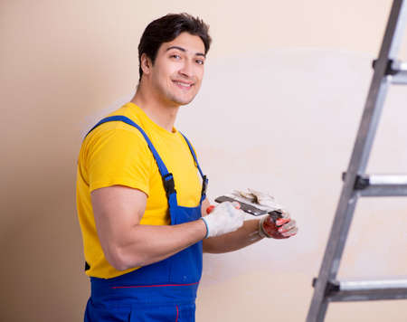 Young contractor employee applying plaster on wallの写真素材