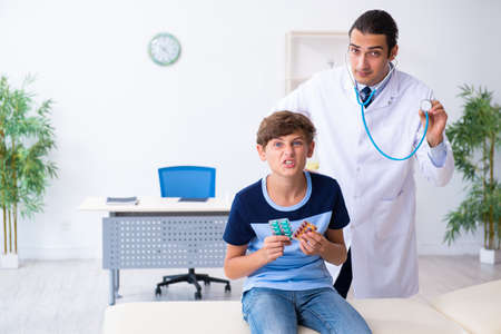 Young male doctor examining boy in the clinicの写真素材