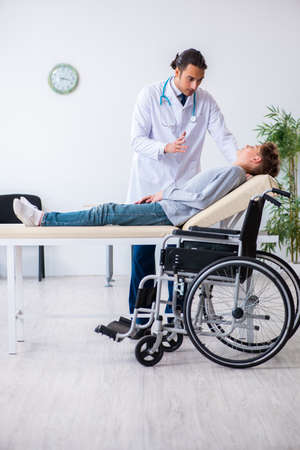 Young male doctor pediatrics and boy in wheel-chairの写真素材