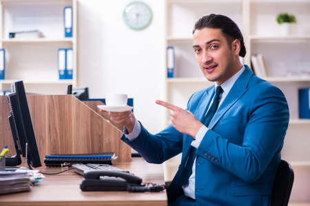 Young handsome businessman sitting in the officeの写真素材