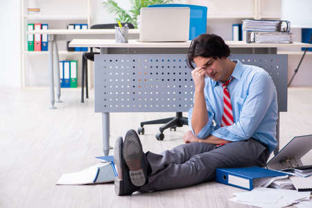 Young male employee unhappy with excessive workの写真素材