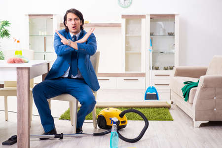 Young businessman cleaning the houseの写真素材