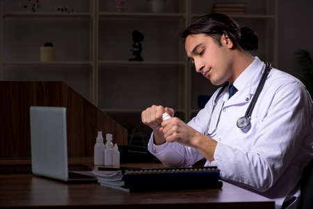 Young male doctor in the hospital at nightの写真素材