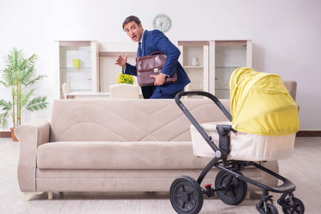 Young businessman looking after babyの写真素材