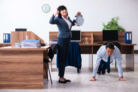 Male employee doing sport exercises in the officeの写真素材