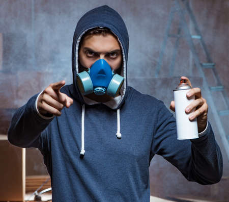 Graffiti painter in dark smokey roomの写真素材