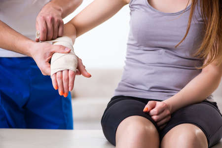 Fitness instructor helping woman during exerciseの写真素材