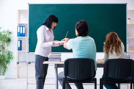 Old teacher and students in the classroom