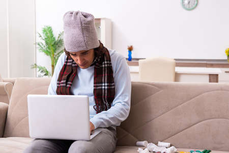 Young man suffering from flu at homeの写真素材