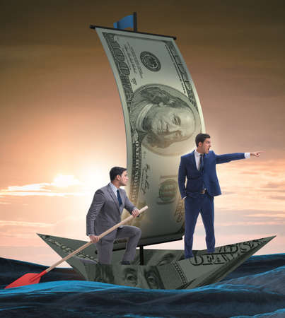 The business partnership with businessmen sailing on dollar boatの写真素材