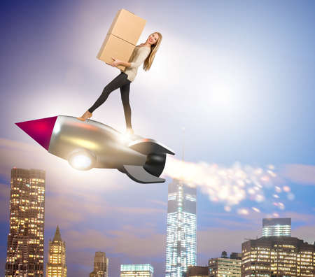 Woman in fast box delivery service on rocketの写真素材