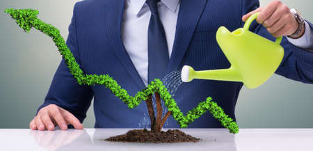 Businessman in investment concept watering financial line chartの写真素材