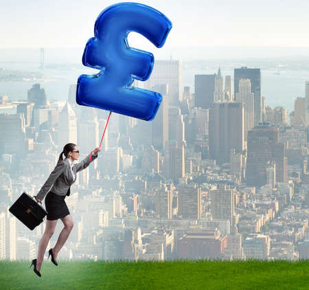 The businesswoman flying on british pound sign inflatable balloonの写真素材