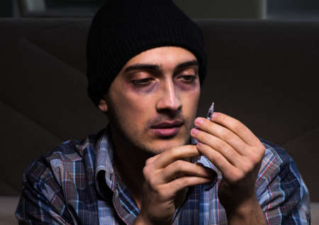 The young man in agony having problems with narcoticsの写真素材