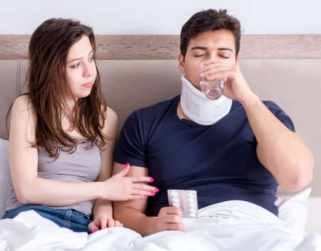 The loving wife taking care of injured husband in bedの写真素材