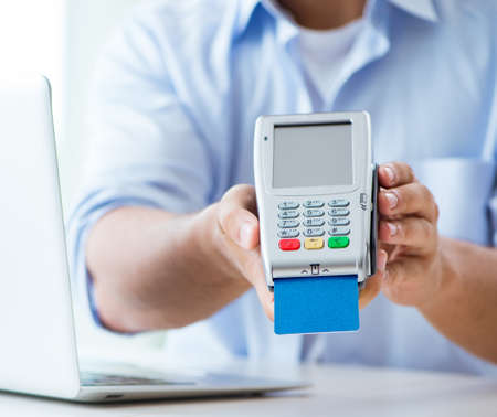 Man processing credit card transaction with POS terminal