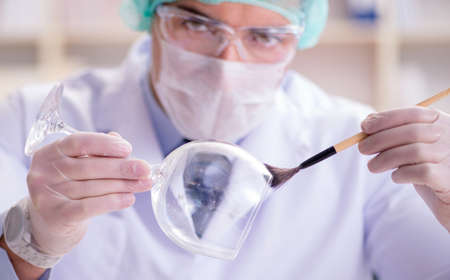 Forensics investigator working in lab on crime evidenceの写真素材
