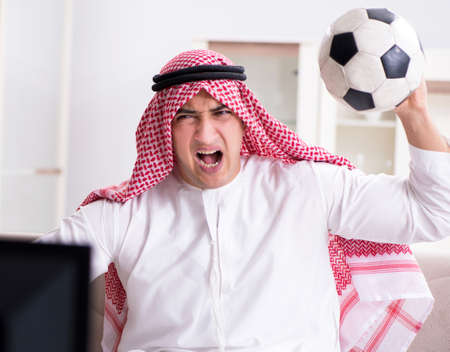 Arab man watching tv at homeの写真素材