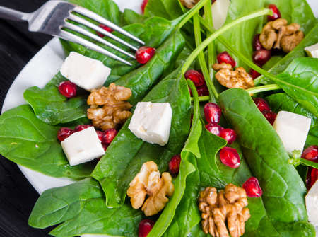 Spinach salad with nuts and apples served on tableの写真素材