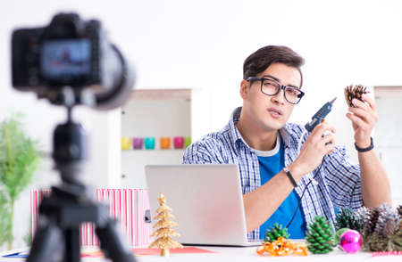 Young vlogger recording video doing christmas decoration