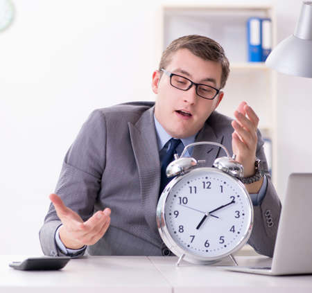 Businessman employee in urgency and deadline concept with alarmの写真素材