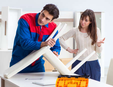 Contractor repairman assembling furniture under woman supervisioの写真素材