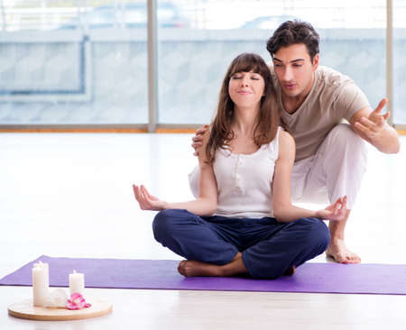 Personal coach helping during yoga sessionの写真素材