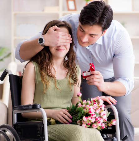 The man making marriage proposal to disabled woman on wheelchairの写真素材