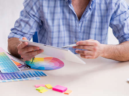 Young designer working in his studio on new projectの写真素材