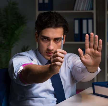 Employee relieving stress from overtime with drugs narcoticsの写真素材