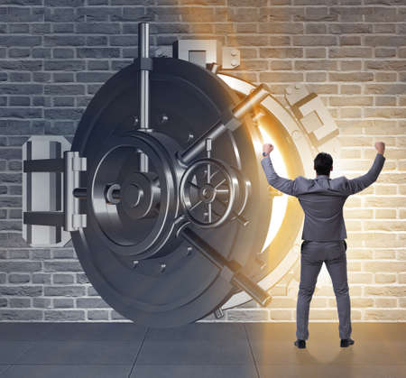 Businessman in front of banking vault doorの写真素材