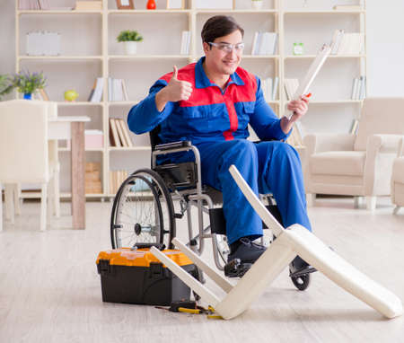 Disabled man repairing chair in workshopの写真素材