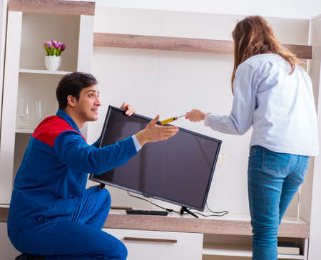 Repairman repairing tv at homeの写真素材