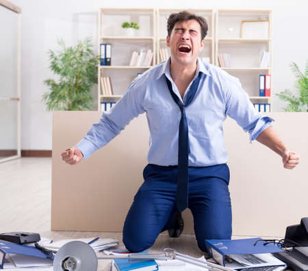 Angry businessman frustrated with too much workの写真素材