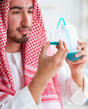 Arab chemist checking the quality of drinking waterの写真素材