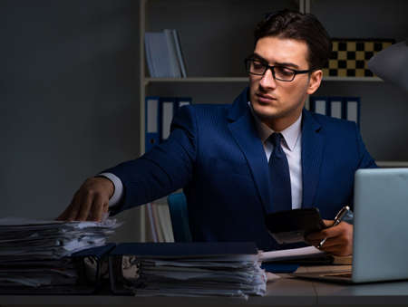 Businessman working late at night in office for overtime bonusの写真素材