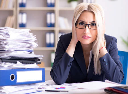 Busy businesswoman working in office at deskの写真素材